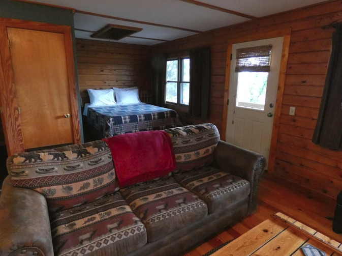 Cliffside cabin at dusk with warm interior light
