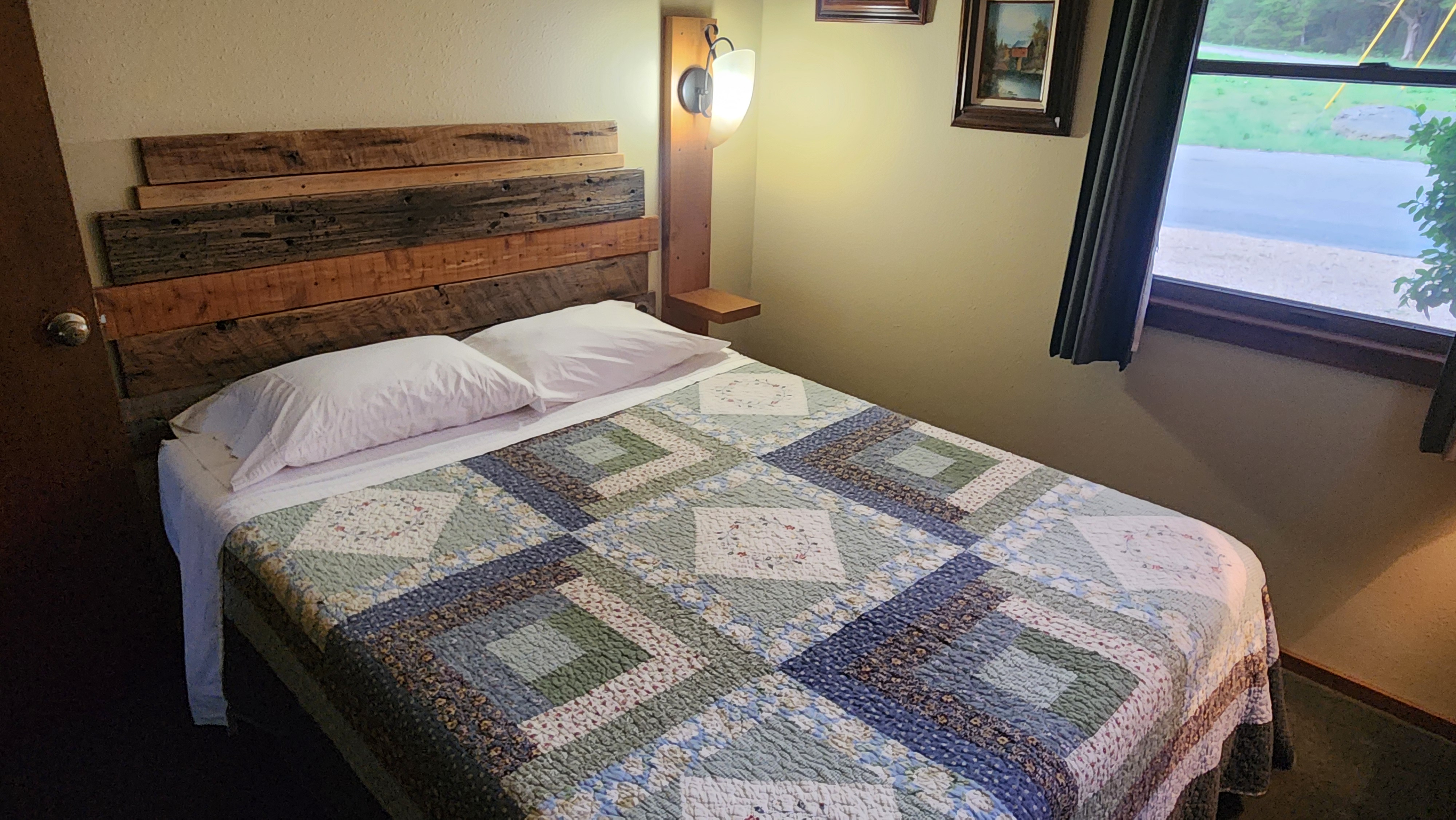Valley View guest bedroom with patchwork quilt and wood plank headboard