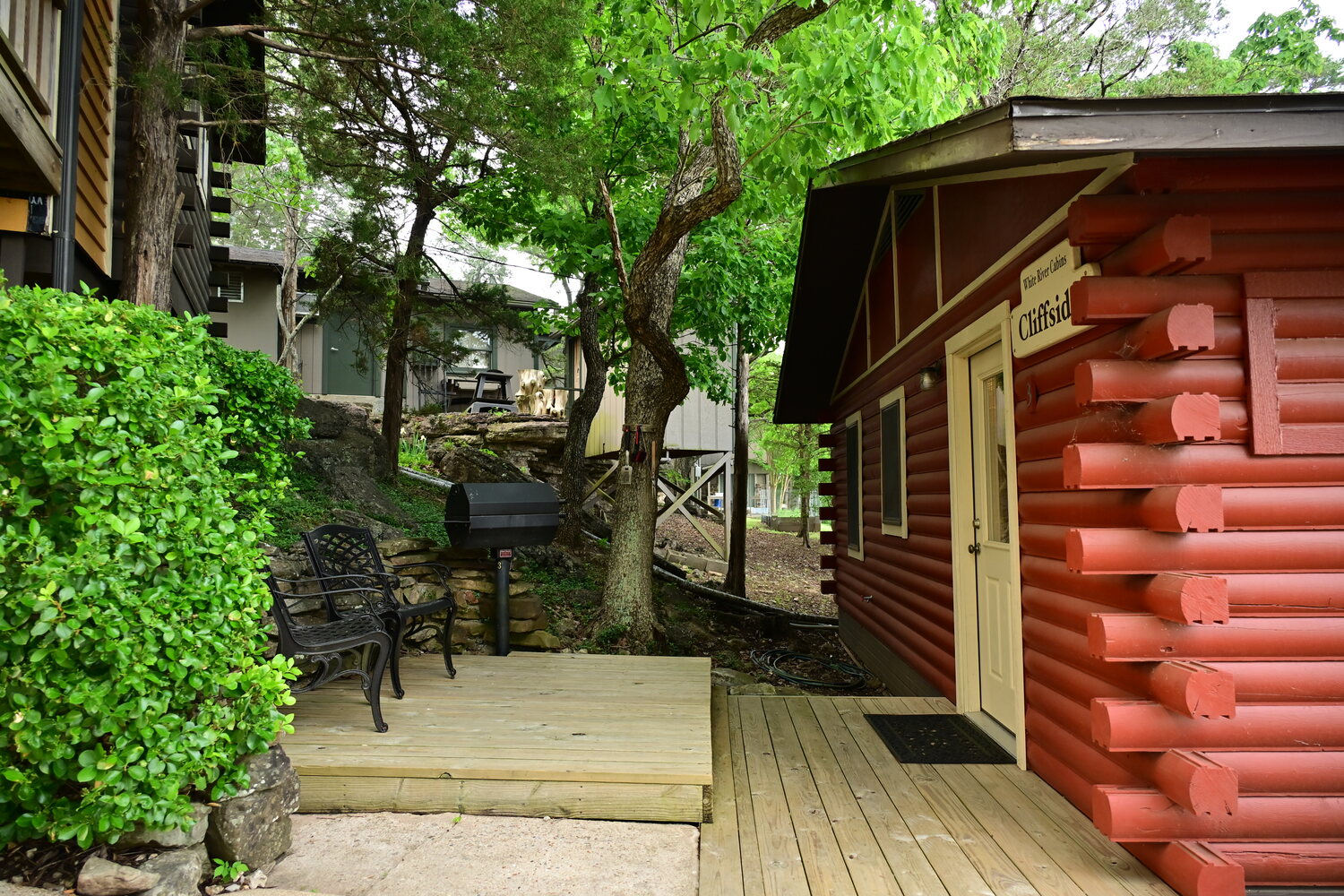Red cabin framed by lush green foliage along a garden path