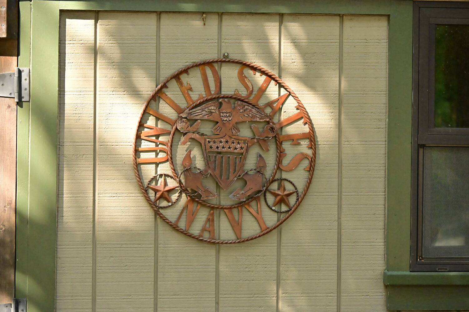 United States Navy emblem mounted on a cabin wall, marking this veteran-owned property