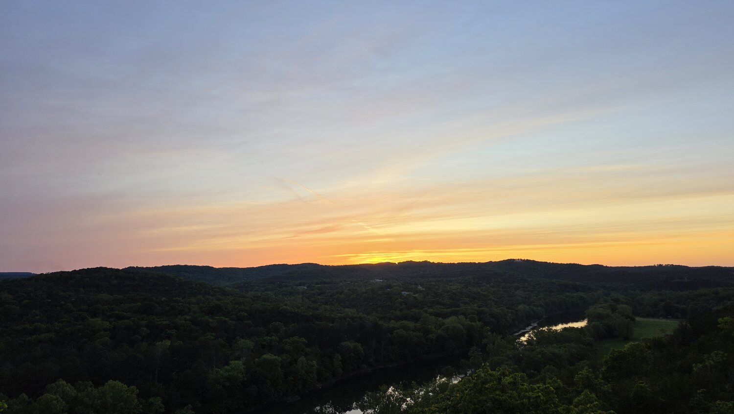 Pastel pink and blue dusk sky fading over the Ozark Mountains