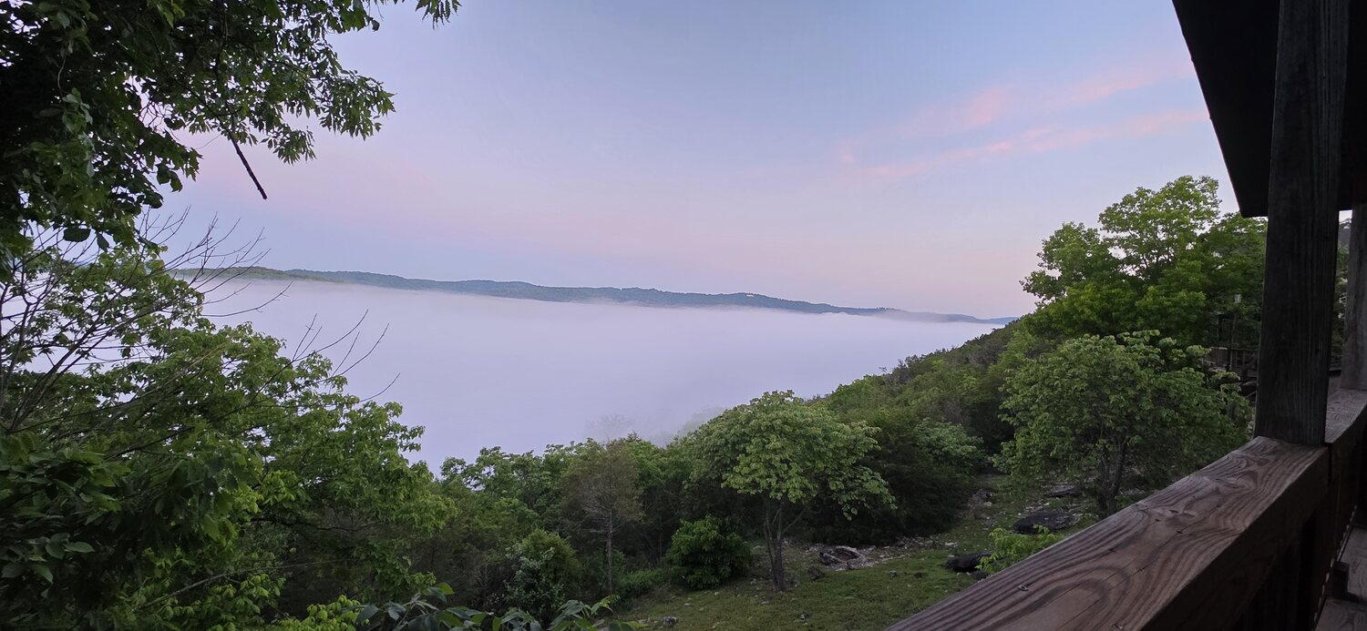 Soft purple pre-dawn light over the calm White River, 450 feet below the cabins