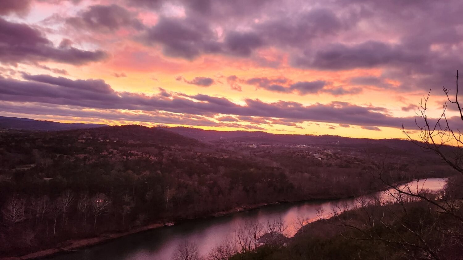 Vivid orange sunset reflected on a bend of the White River below the Ozark bluffs
